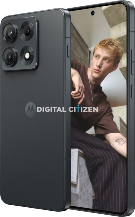 gsmarena_001 Smartphone held tilted to show its back camera array while the screen displays a portrait of a blond man sitting on concrete stairs, with a Digital Citizen watermark on the screen.