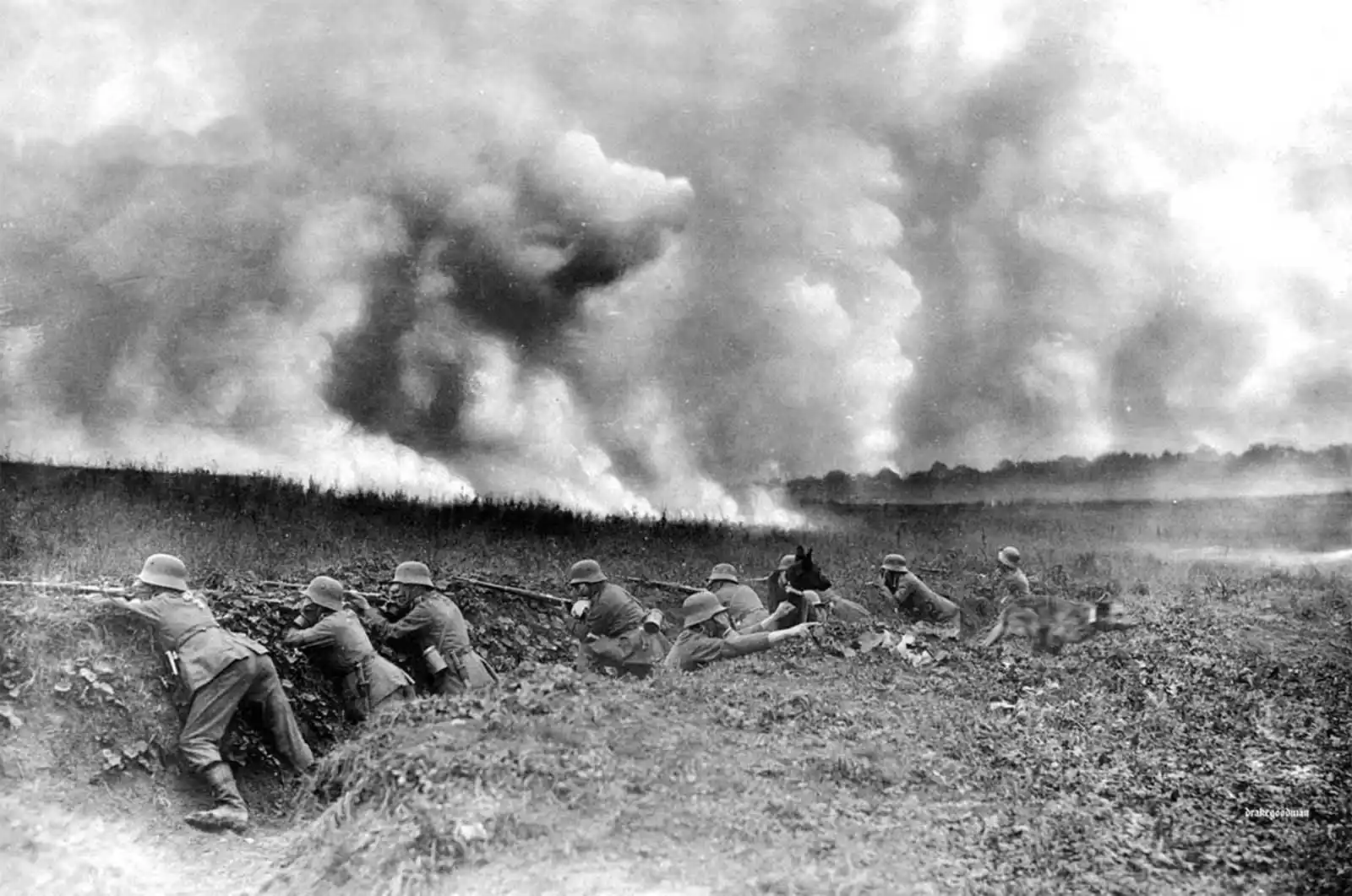 Soldiers in a trench firing rifles as a cloud of smoke rises from a battlefield behind them (WWII-era scene).